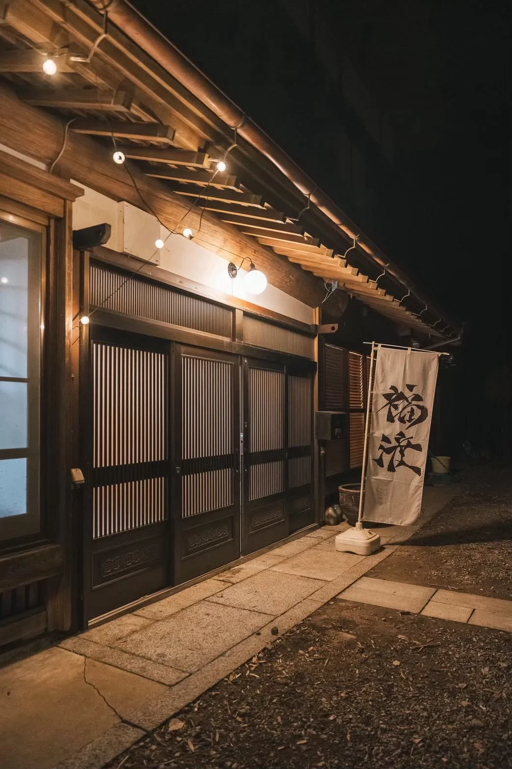 Warm lights at the entrance to Fukuwatari Tei after dark