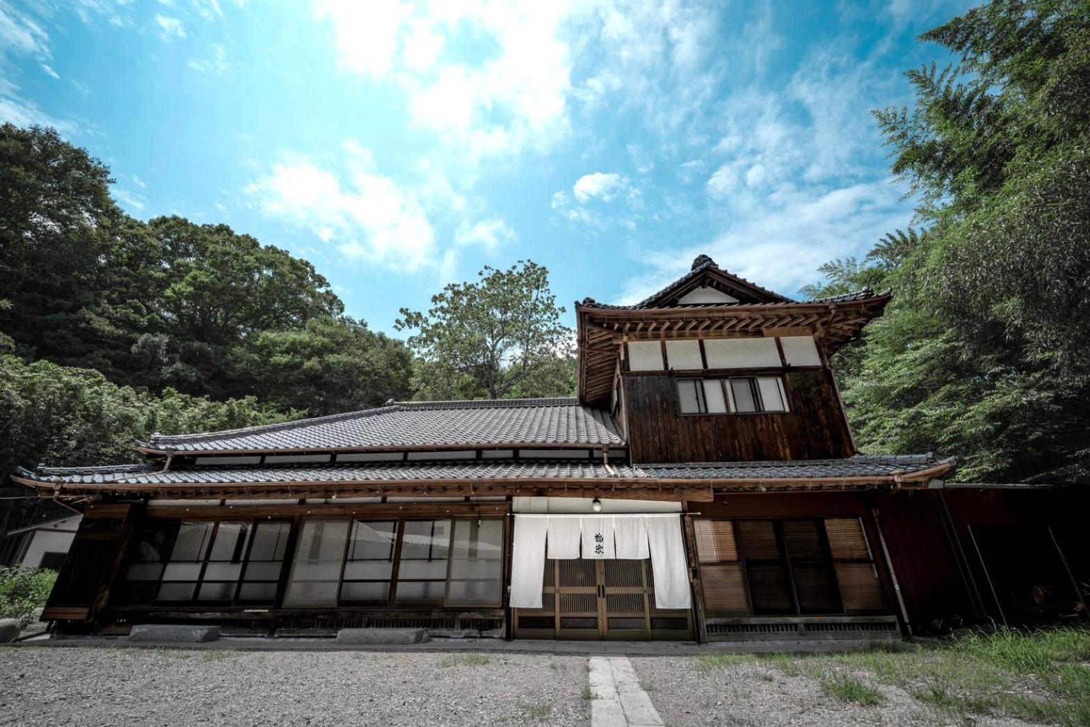 Fukuwatari residence and its tree-lined private grounds under a blue sky